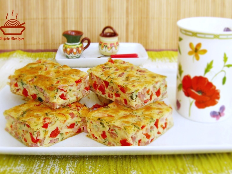 Porții de budincă aperitiv cu șuncă și ardei pe un platou alb